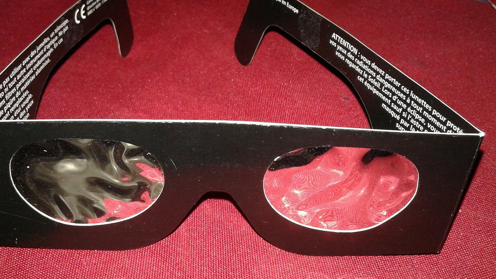 Une personne observe une éclipse solaire à Paris à travers des lunettes de protection en 1999