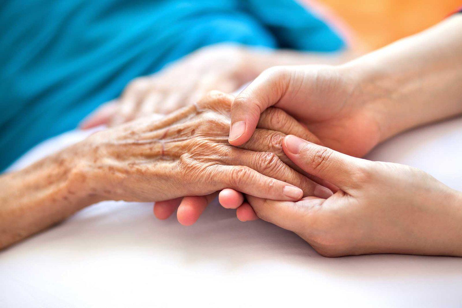La main d'un soignant tenant celle d'un patient