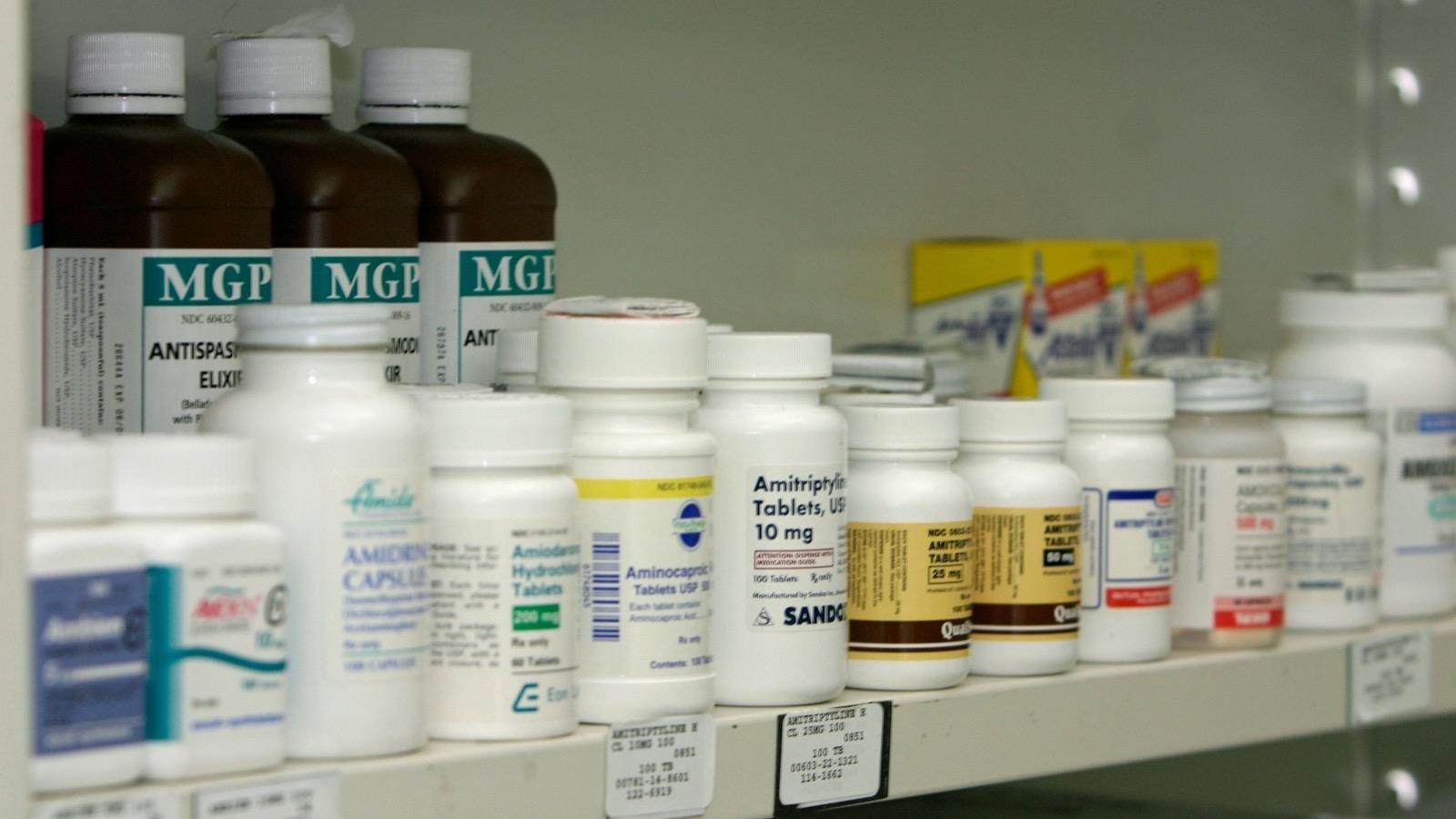 Des boîtes de médicaments rangées sur les étagères d'une pharmacie