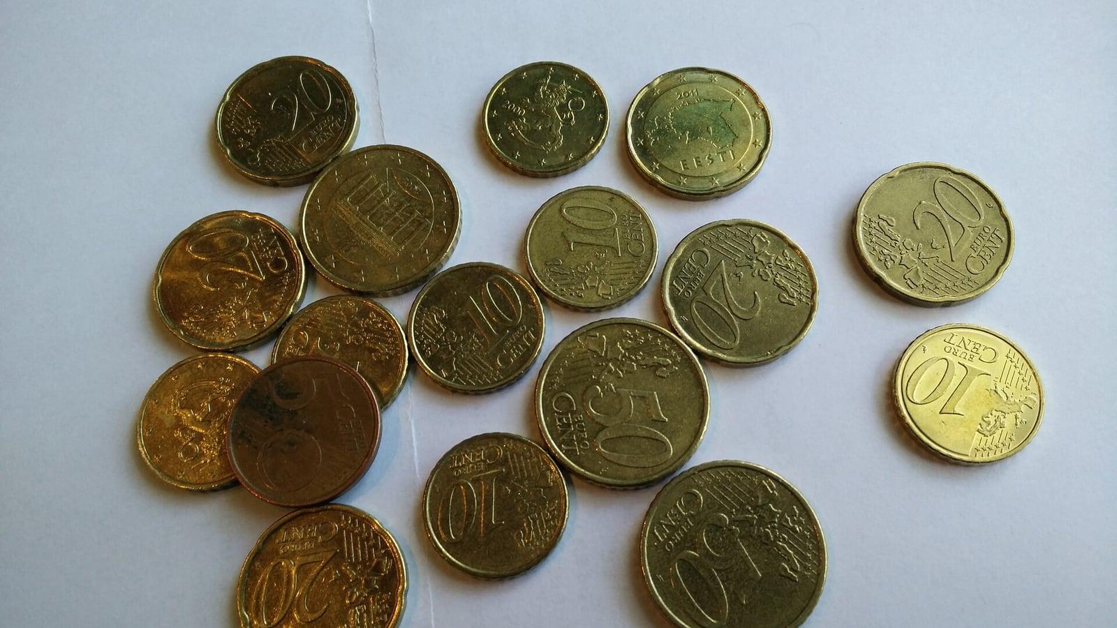 Une poignée de pièces de 5, 10, 20 et 50 centimes d'euro éparpillées sur une feuille blanche
