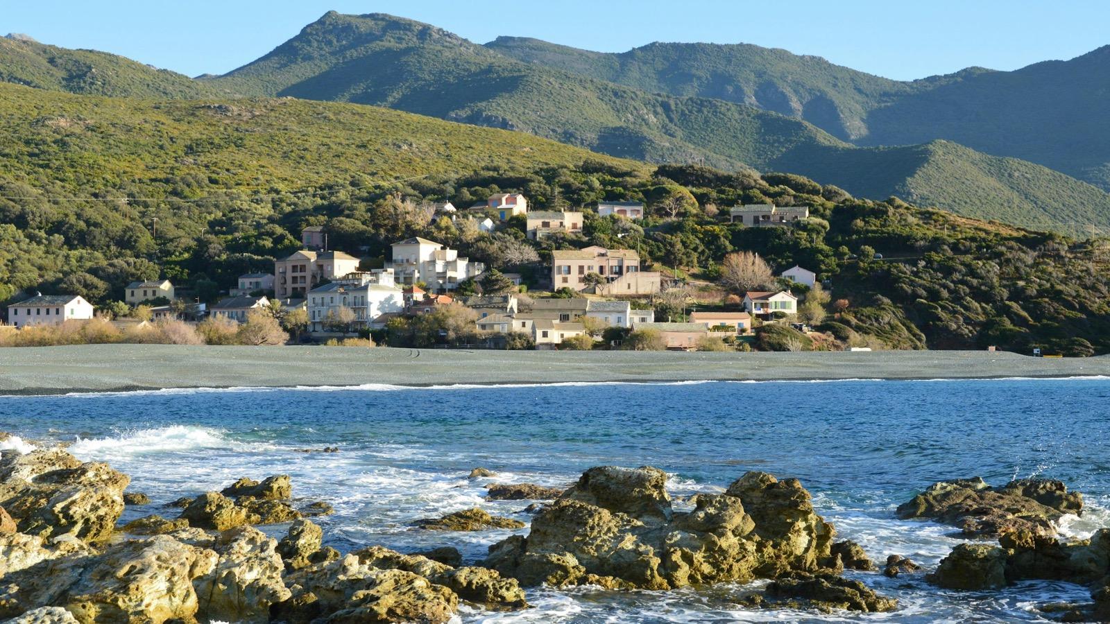 Un village côtier accroché à flanc de colline face à la mer
