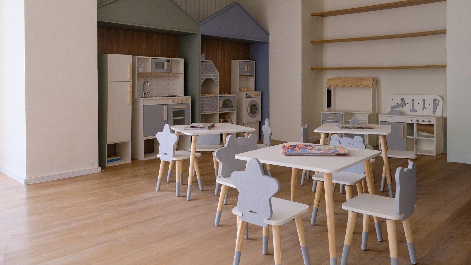 Une salle de jeux d'enfants avec petites tables et chaises