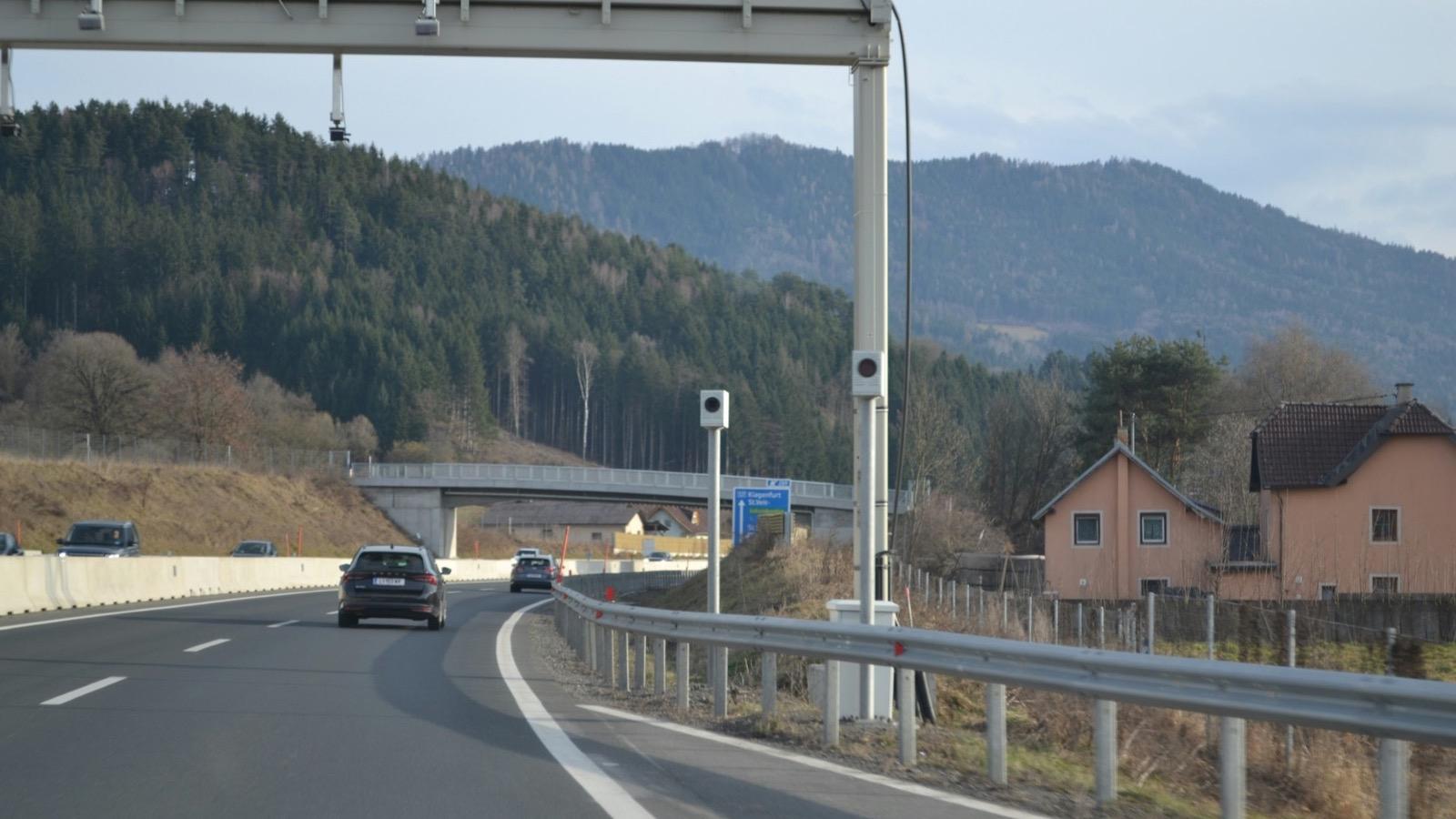 Des voitures circulant sur une voie rapide bordée de collines boisées