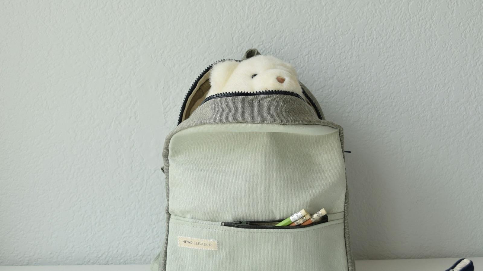 Un cartable et des fournitures scolaires posés sur une table