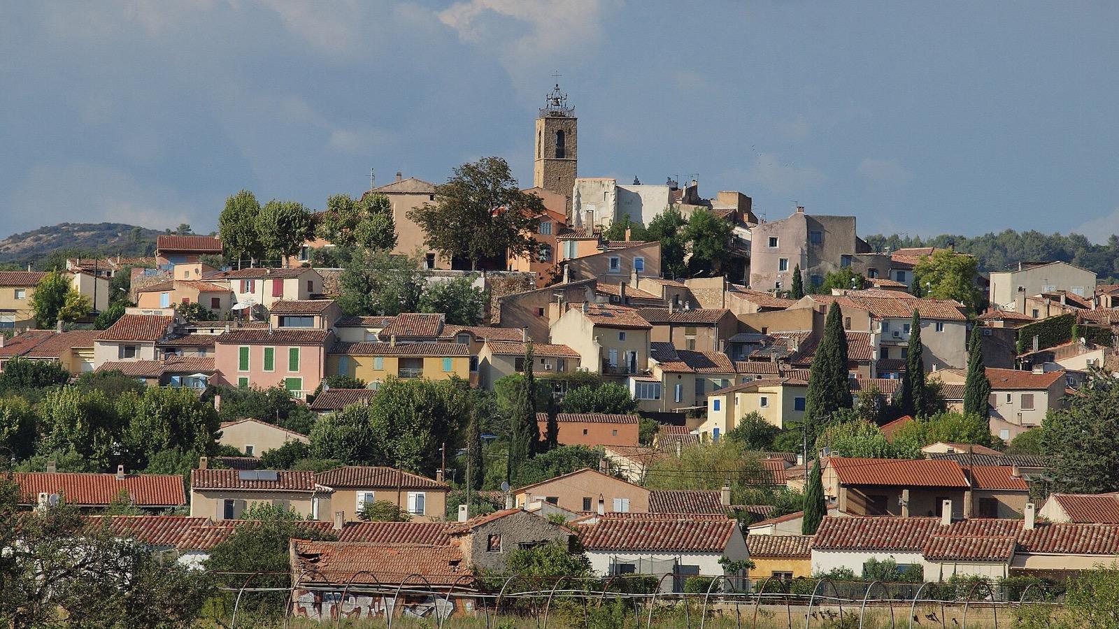 Projection de cinéma en plein air sur une place de village provençal à la nuit tombée